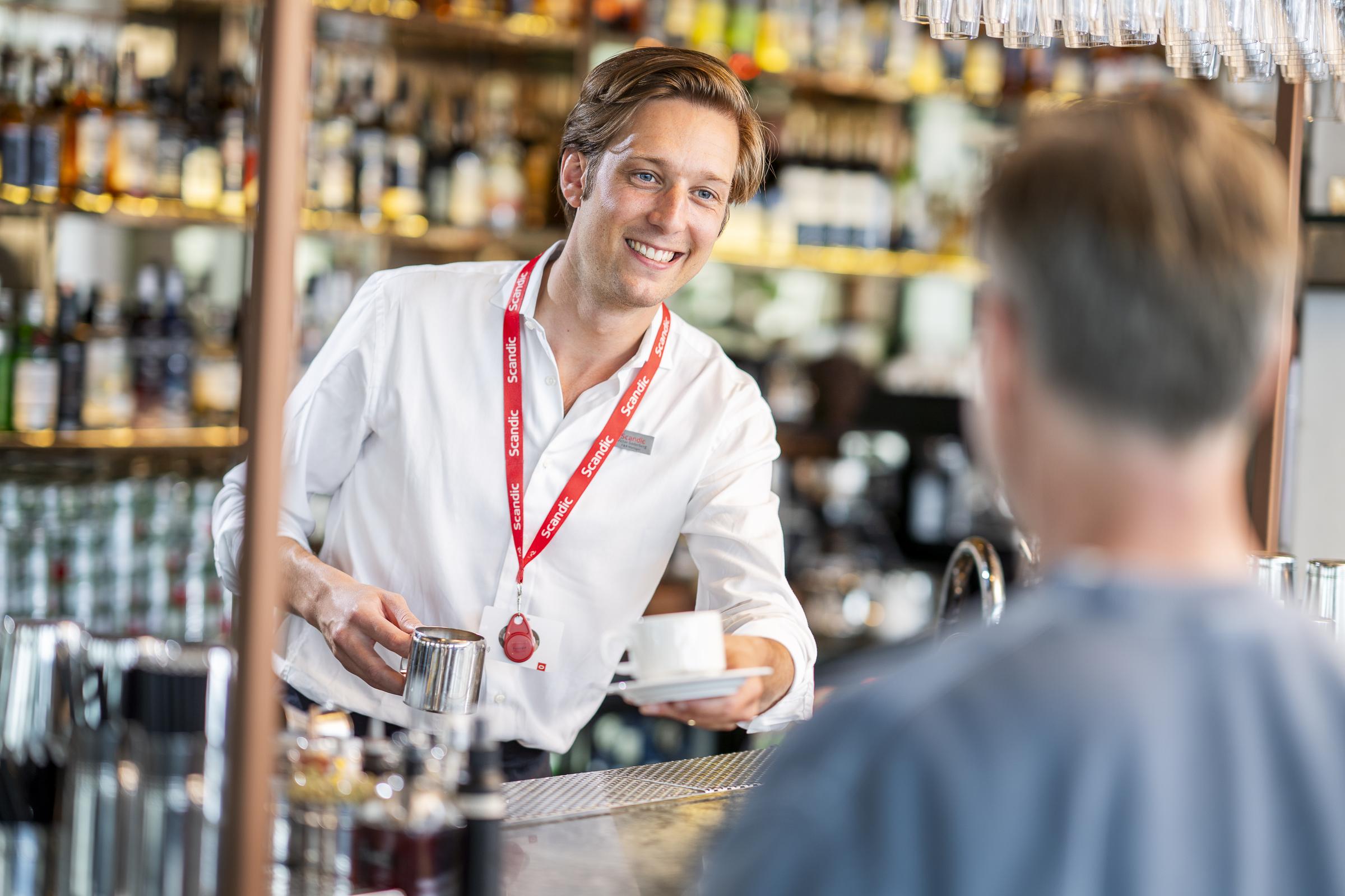 Team member serving coffee in the bar