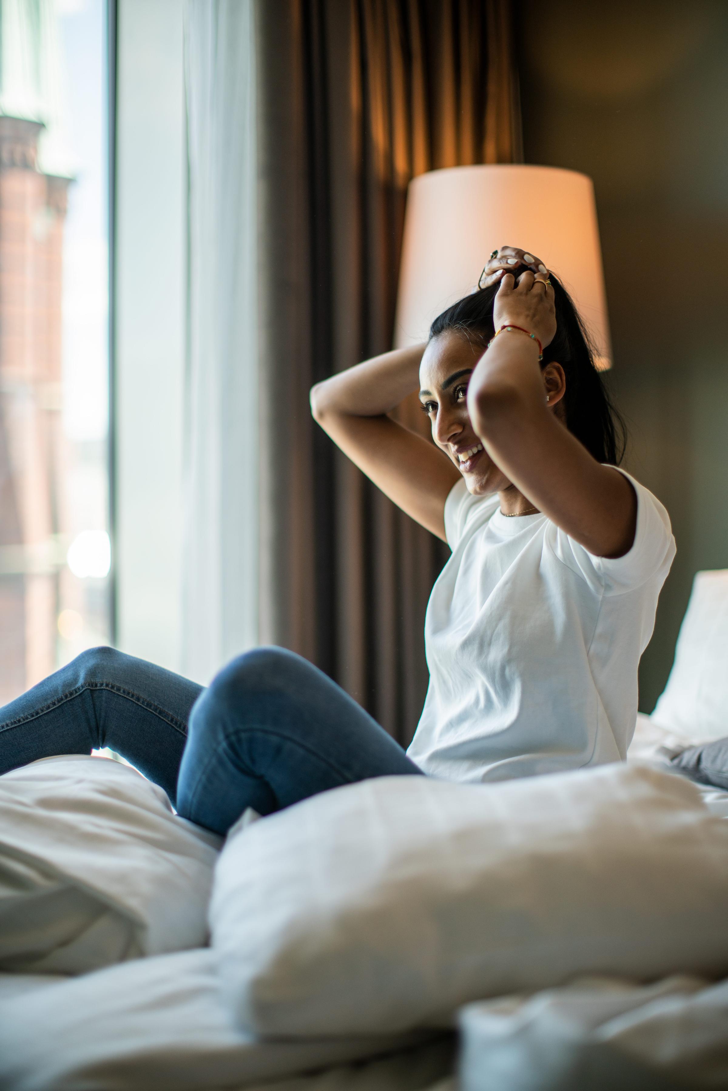 Laughing woman sitting in a bed 