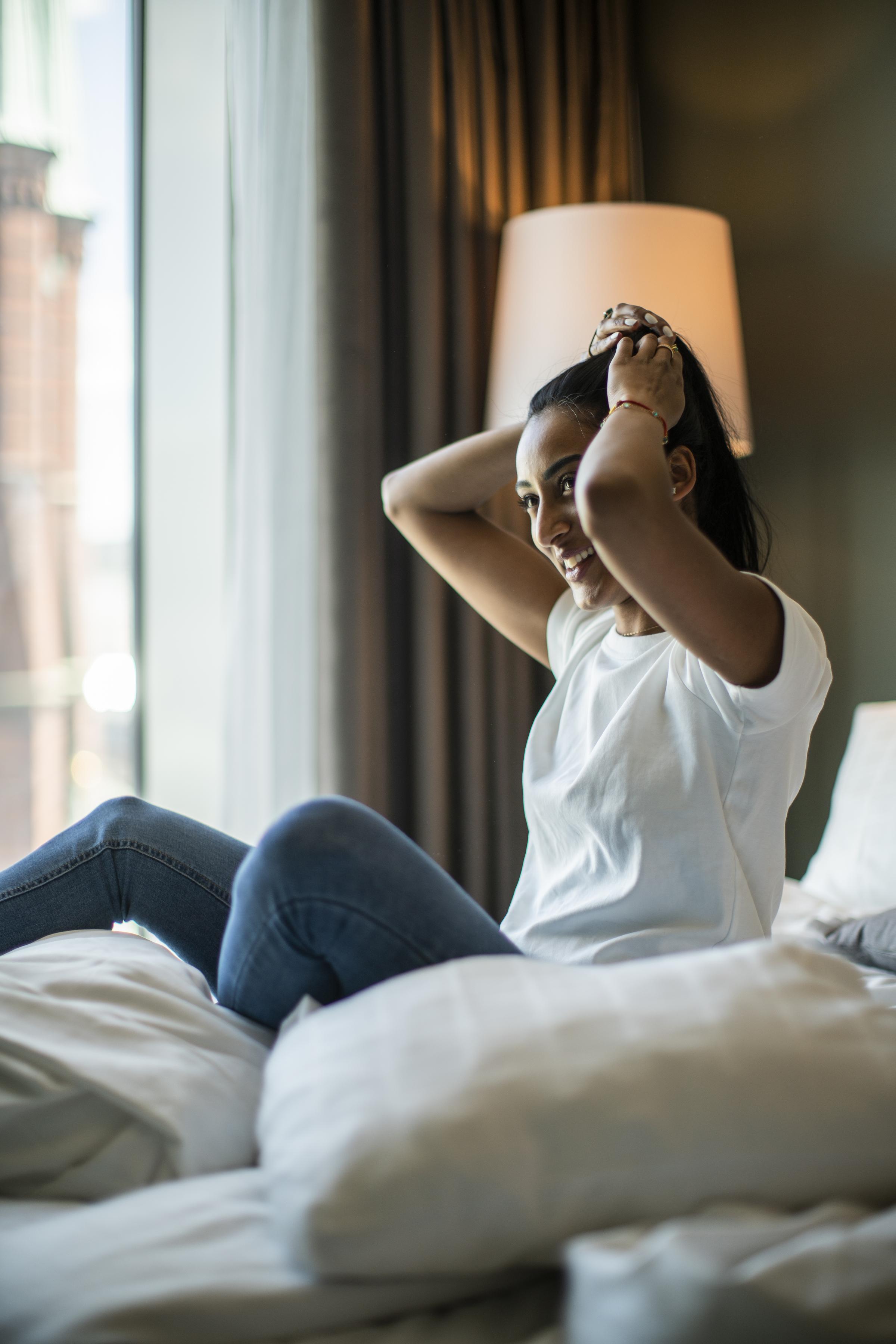 Laughing woman sitting in a bed 