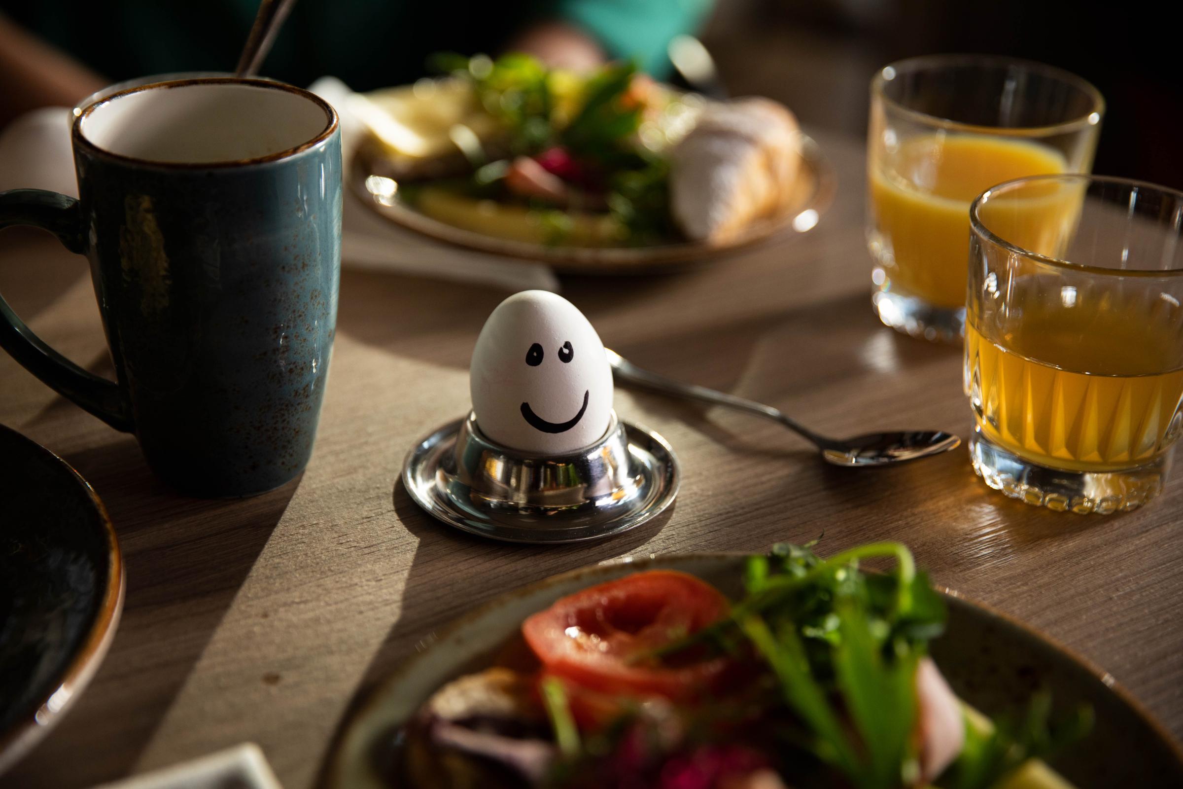 A egg with a smiley face on the breakfast table