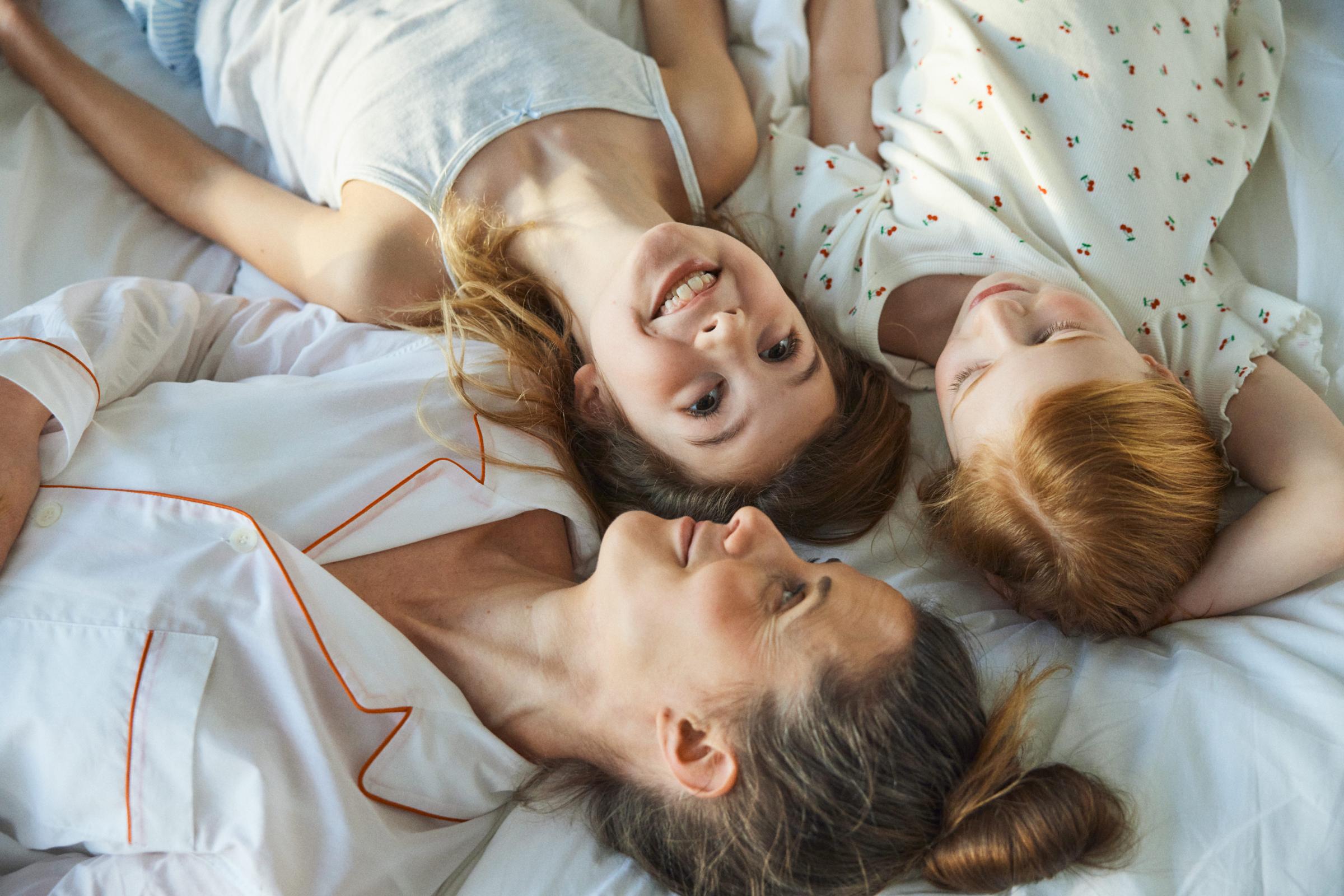A mother with two daughters in pyjamas in bed