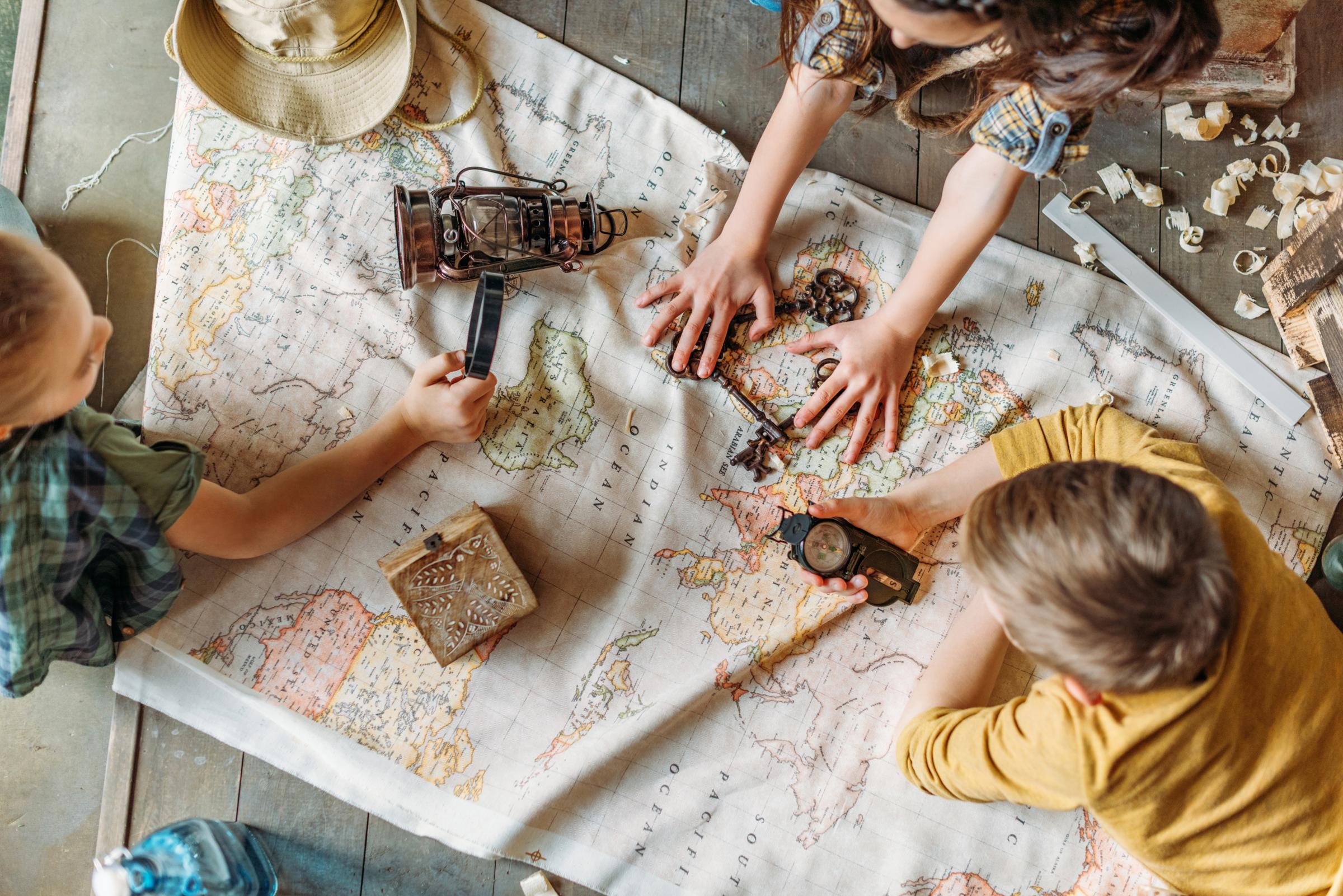 Kids playing with a world map.