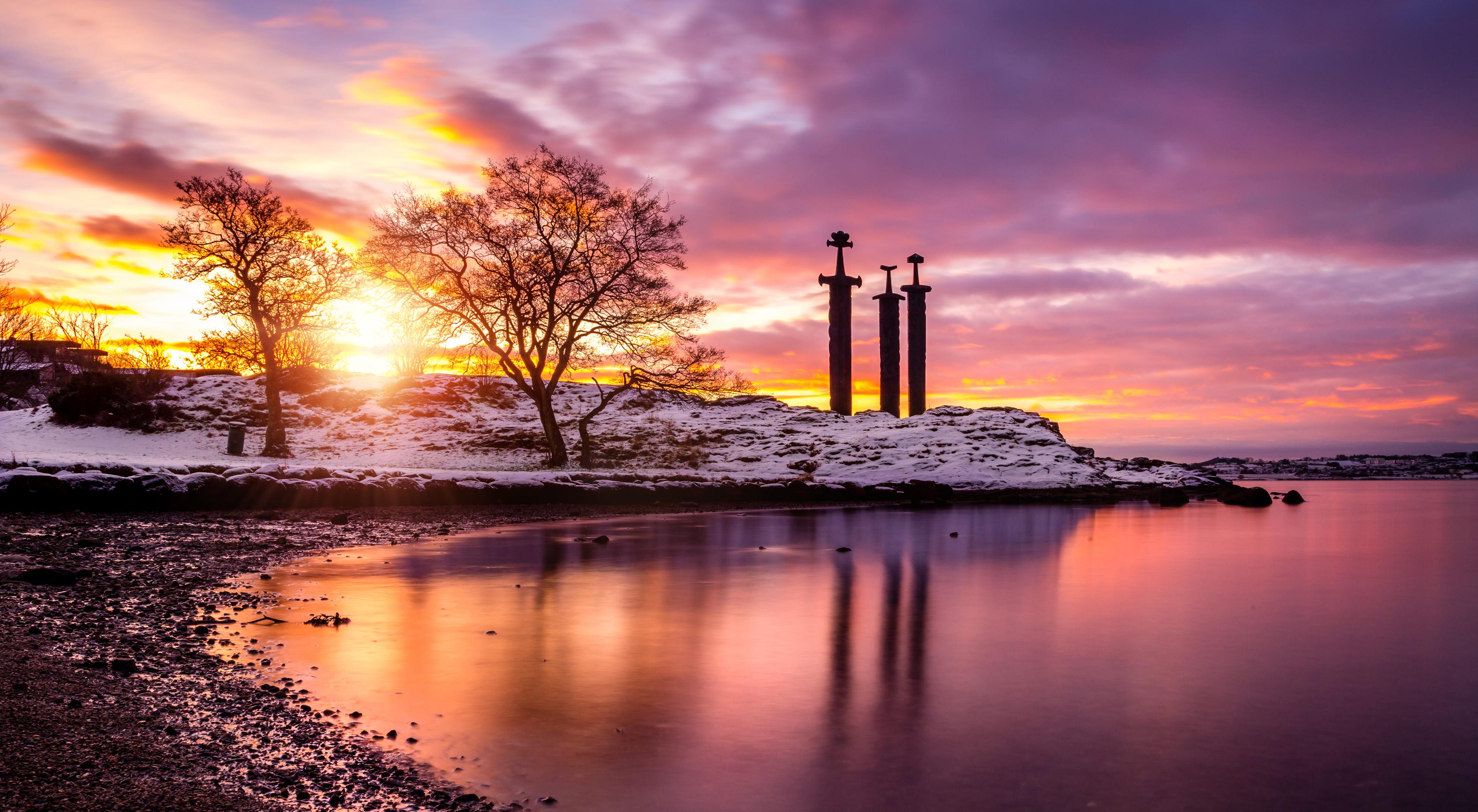 Beautiful sunrise in the back of the snowy monument, 3 swords outside of Stavanger