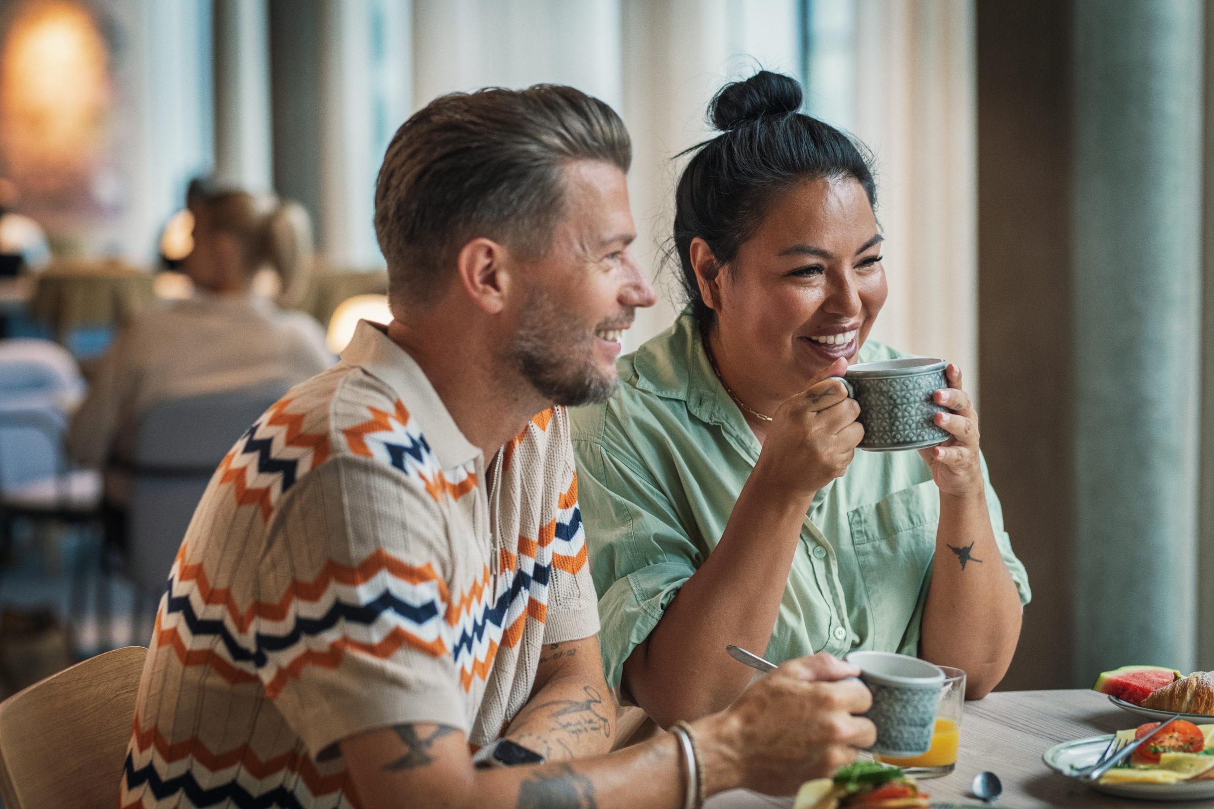 A couple sitting at a table having breakfast